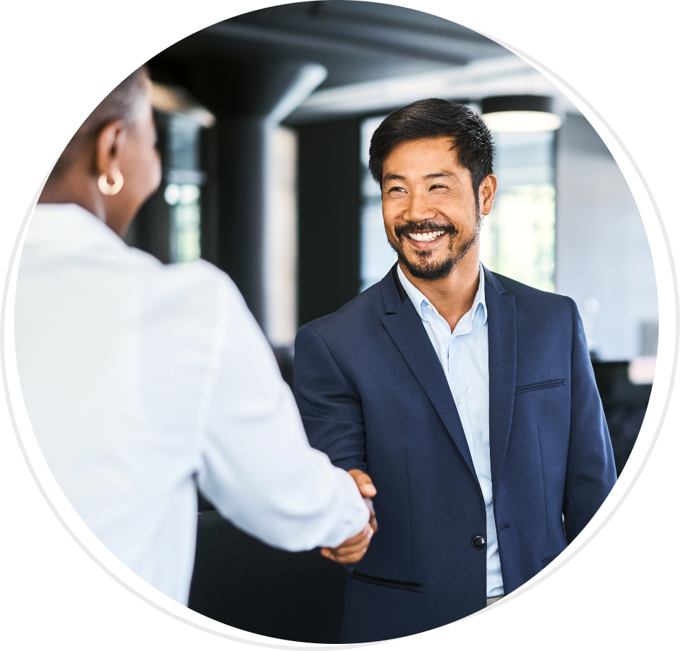 A man in a suit smiles while shaking a woman's hand