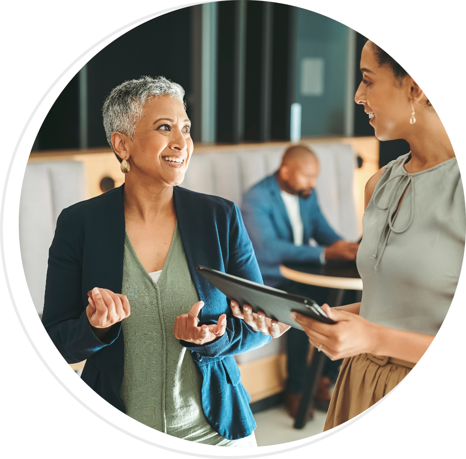 two smiling women standing while having a conversation